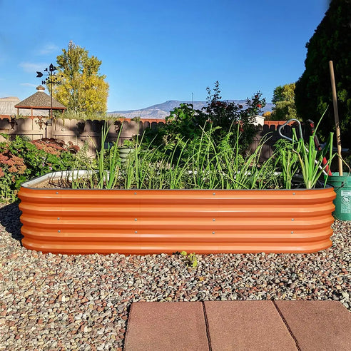 orange metal planter box growing scallions in the backyard