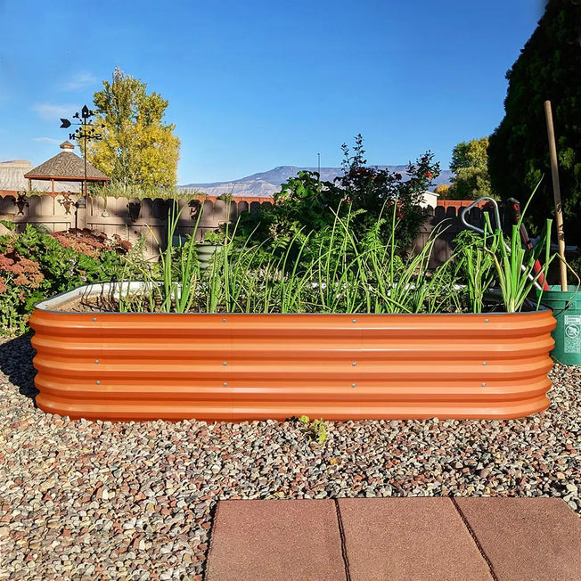 orange metal planter box growing scallions in the backyard