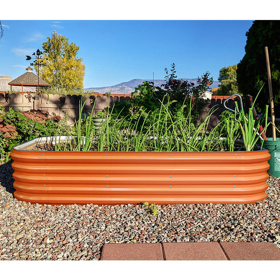 orange metal planter box growing scallions in the backyard